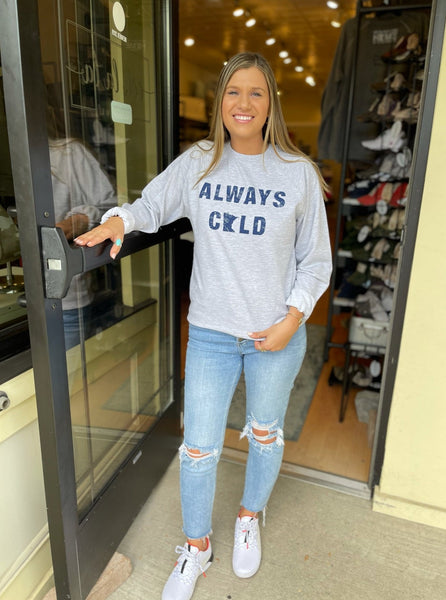 Young woman standing in Ooh La La Boutique MN doorway wearing Connie's Tees Always Cold Crewneck in Heather Grey with Navy print